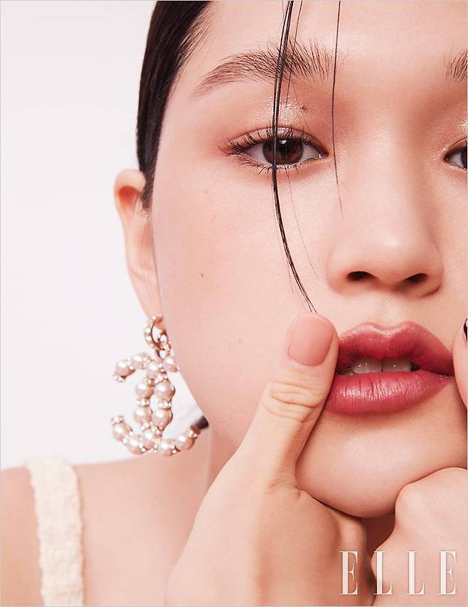 수현의 피부에 싱그러움을 부여하기 위해 울트라 르 뗑 쿠션, BR12를 얼굴 가운데 중심으로 가볍게 터치. 레 꺄트르 옹브르, 352 엘리멘탈을 바른 눈꺼풀에 바움 에쌍씨엘 글로우 스틱, 트렌스페어런트를 덧발라 섬세한 광채를 더한다. 루쥬 알뤼르, 198 누앙스를 입술에 고르게 발라 로즈우드빛으로 물들이면 완성. 사용 제품은 모두 Chanel. 슬리브리스 원피스와 이어링은 모두 Chanel.