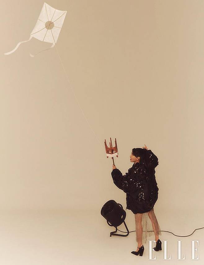 반짝이는 스팽글 장식이 돋보이는 애비에이터 재킷과 메탈릭 소재의 스커트, 블랙 펌프스는 모두 Prada.