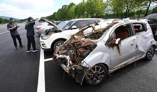 10일 오전 경기 과천시 서울대공원 주차장에서 보험 관계자들이 폭우 때 침수된 차량을 점검하고 있다. 배우한 기자