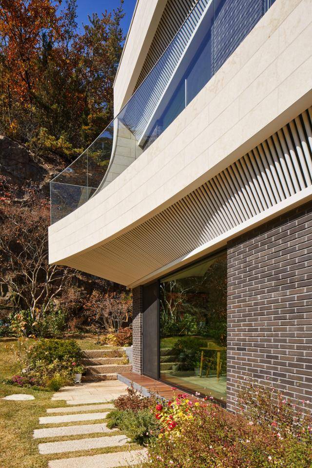 1층 거실과 부엌으로는 바닥 레벨의 낮은 단을 외부로 설치해 안정감을 줬다. 노경 건축사진작가 제공