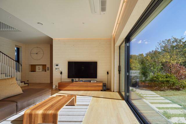 건축주 부부가 가장 많은 시간을 보내는 거실의 벽면은 밝은 색상 석재로 마감해 아늑한 느낌을 연출했다. 거실과 부엌의 앉은 자리에서는 창 너머로 정원과 관악산의 능선이 펼쳐진다. 노경 건축사진작가 제공