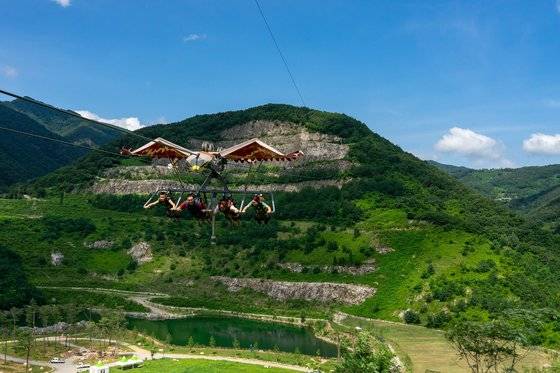지난 5일 동해시 무릉별유천지에서 한 가족이 독수리 모양의 ‘스카이 글라이더’를 체험하고 있다. 40여년 석회석을 캐던 광산을 304억원을 투입해 관광 단지로 개발한 장소다. 주말마다 2000명가량이 몰릴 만큼 인기가 높다.