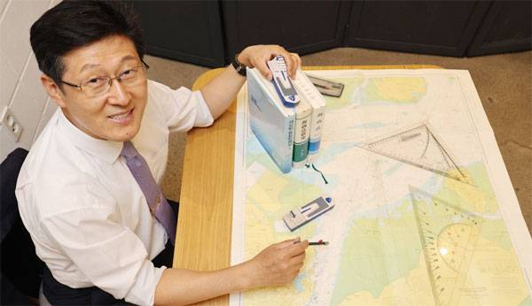 김인현 고려대 법학전문대학원 교수는 선장 시절 불의의 사고를 당한 경험을 딛고 국내 최고 해상법 전문가가 됐다. 김 교수가 서울 성북구 고려대에서 해도와 자신의 책을 보여주며 웃고 있다. [이충우 기자]