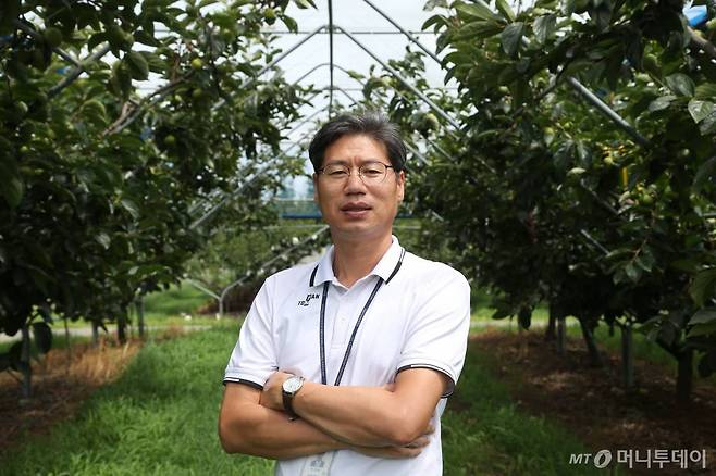 마경복 박사가 지난 8일 전남 나주 국립원예특작과학원 배연구소 단감 포장에서 팔짱을 한 채 활짝 웃고 있다. /사진=정혁수