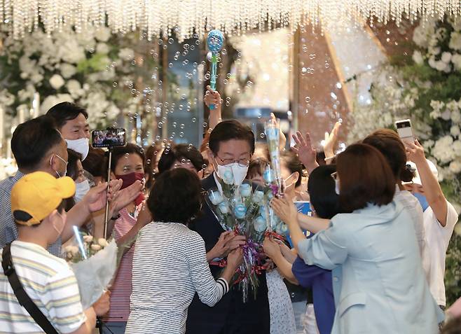 이재명 더불어민주당 의원이 8월4일 '울산 당원 및 지지자와의 만남'에 참석해 지지자들로부터 장미꽃을 받고 있다.ⓒ뉴스1