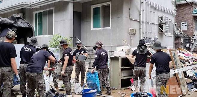 수해 복구 대민 지원에 나선 52사단 햇불여단 장병들이 대규모 수해를 입은 서울 관악구 신대방동에서 침수로 못 쓰게 된 물건들을 정리하고 있다.