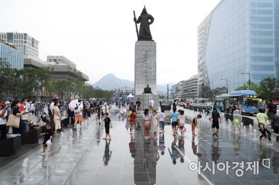 서울 광화문광장이 개장한 6일 시민들이 광장 내 분수에서 더위를 식히고 있다. /문호남 기자 munonam@