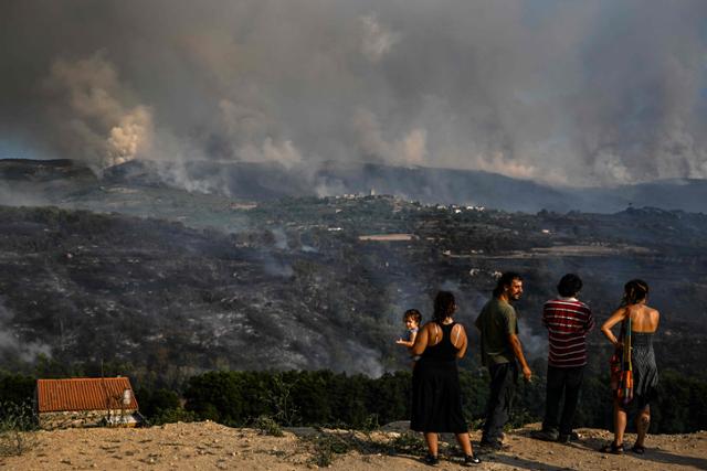 포르투갈 북부 셀로리쿠다 베이라의 리냐리스에서 11일 주민들이 대형 산불을 바라보고 있다. 리냐리스=AFP 연합뉴스