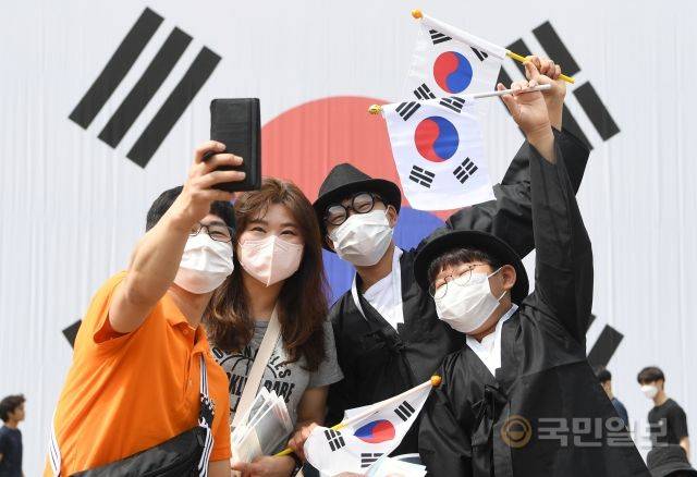 광복절 77주년을 하루 앞둔 14일 시민들이 서울 서대문형무소역사관 앞 대형 태극기 앞에서 기념촬영을 하고 있다.