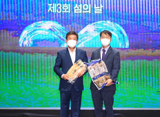 남한권(왼쪽)울릉군수와  강임준 군산시장이 지역 특산품인 울릉도 오징어와  군산 박대를 교환한후 기념사진을 찍고 있다