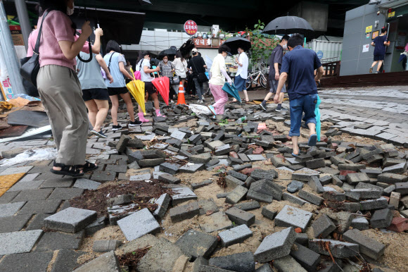 서울 동작구 신대방역 앞 보도블록이 폭우로 파손돼 출근길에 나선 시민들이 불편을 겪고 있다. 2022.8.9 연합뉴스