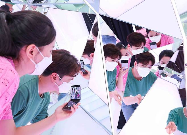 삼성전자는 ‘갤럭시 Z폴드 4'와 '갤럭시 Z플립 4’ 사전 판매를 16일부터 22일까지 7일간 진행한다고 15일 밝혔다. 사진은 갤럭시 스튜디오 삼성 디지털프라자 홍대본점에서 방문객들이 '갤럭시 Z플립 4'로 거울 셀카를 찍는 모습. /삼성전자 제공