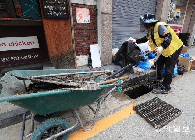 15일 지난주 집중호우로 수해피해를 입은 서울 관악구 신사동에서 구청 관계자들이 빗물받이 청소작업을 하고있다.