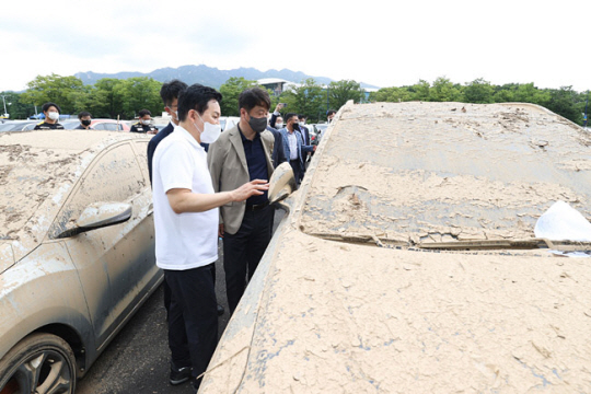 원희룡(왼쪽 첫번째) 국토교통부 장관이 15일 경기 과천시 서울대공원 침수차 임시 적치장에서 손해보험사 관계자들과 침수차 상태를 살펴보고 있다. 뉴시스