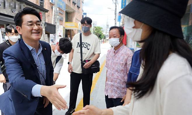 더불어민주당 당 대표 선거에 나선 박용진 의원이 15일 광주 동구 동명동 카페의 거리를 찾아 젊은이들과 인사를 하고 있다. 연합뉴스