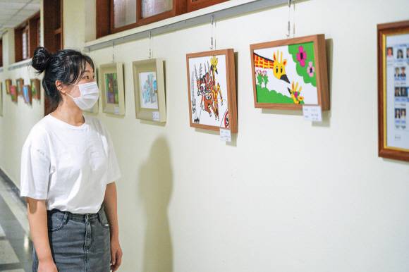한 구로구청 직원이 청사 5층 복도에 전시된 발달장애인들의 그림을 감상하고 있다.구로구 제공