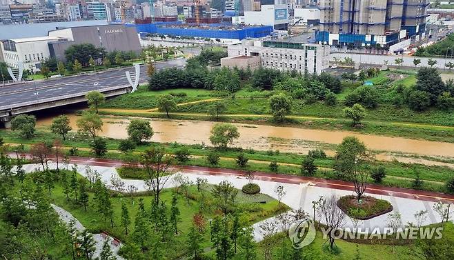 흙탕물 흘러가는 대전 진잠천 (대전=연합뉴스) 이은파 기자 = 14일 새벽 대전지역에 쏟아진 폭우로 서구·유성구 일대 도안신도시를 관통하는 진잠천에 흙탕물이 흐르고 있다. 2022.8.14 sw21@yna.co.kr