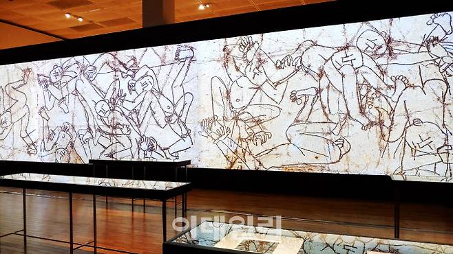 국립현대미술관 ‘이건희컬렉션 특별전: 이중섭’ 전 전경 중 ‘은지화’ 섹션. 담뱃갑 속에 반짝이는 은색 종이를 빼내 넓적하게 누르고 늘려 그 위에 철필이나 못 등으로 새기듯 그린 그림들을 모았다. 손바닥만한 은지화들은 앞쪽 테이블 안에, 뒤로는 그 은지화를 확대한 영상으로 볼 수 있게 했다(사진=오현주 문화전문기자).