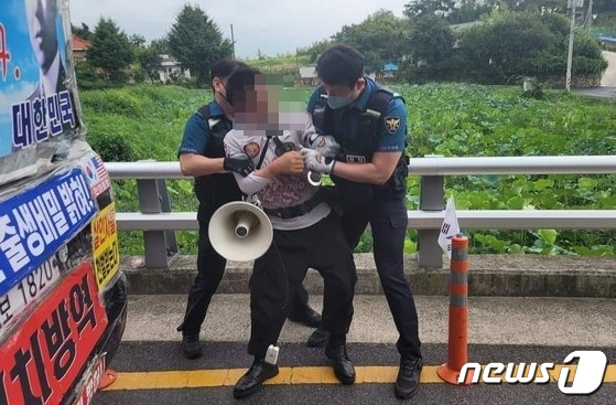 문재인 전 대통령 사저가 있는 양산 하북면 평산마을 앞 도로에서 흉기를 휘두른 60대 남성이 경찰에 체포되고 있다. (독자 제공)