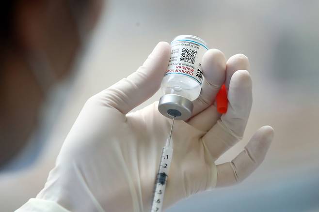 모더나의 코로나19 백신을 주사기에 담는 모습.