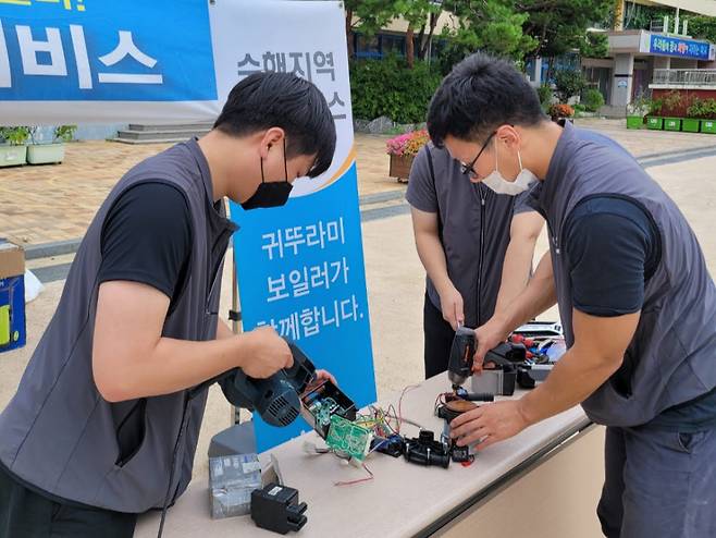 귀뚜라미 관계자가 서울 신림동 서울남부초등학교에 마련한 수해지역 긴급 서비스 캠프에서 제품을 살펴보고 있다.