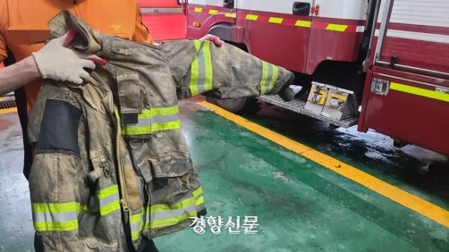 경기 화성의 한 119안전센터에서 근무하는 소방관이 지난 24일 까맣게 변한 방화복을 들어 보이고 있다. |김태희기자