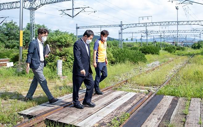 [증평=뉴시스] 강신욱 기자 = 16일 오후 충북 증평군 도안면 화성리 충북선 도안역을 방문한 이재영(가운데) 증평군수가 군청 도시교통과장, 코레일 직원과 건널목을 걷고 있다. (사진=증평군 제공) 2022.08.16. photo@newsis.com *재판매 및 DB 금지