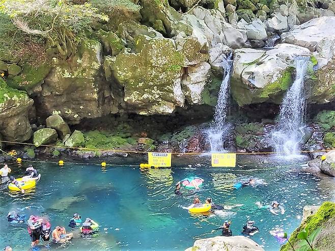 지난 14일 제주 서귀포시 돈내코 원앙폭포를 찾은 피서객들이 물놀이를 하고 있다. 연합뉴스