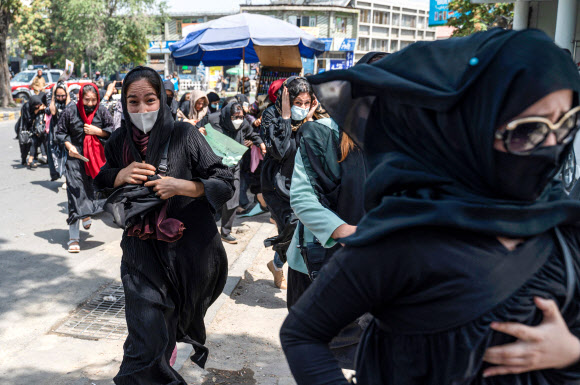 아프가니스탄 카불에서 지난 13일(현지시간) 탈레반 무장대원들이 여성 인권 탄압에 항의하며 거리로 나선 시위대를 향해 발포하자 여성들이 놀라 대피하고 있다.카불 AFP 연합뉴스