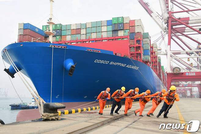 중국 칭다오 항구에서 마스크를 쓴 근로자들이 컨테이너선을 밧줄로 묶고 있다. ⓒ 로이터=뉴스1 ⓒ News1 윤다혜 기자