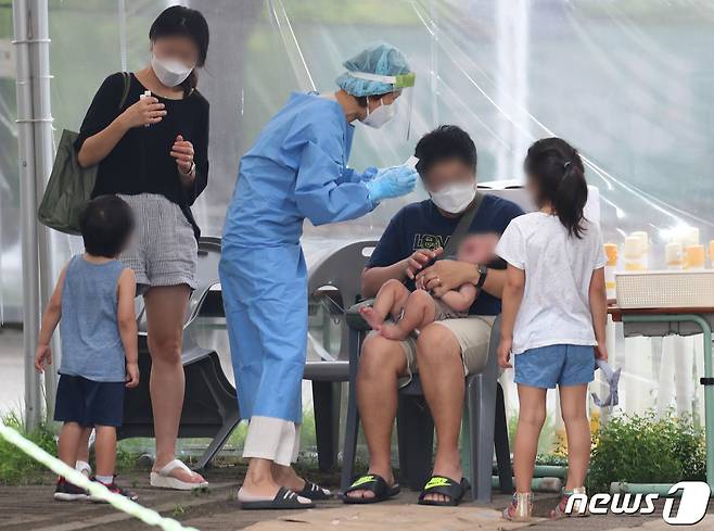 대전월드컵경기장 주차장에 마련된 코로나19 선별진료소에서 한 가족이 진단검사를 받고 있다. ⓒNews1 김기태 기자