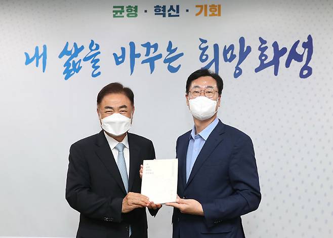 정명근 화성시장(오른쪽)은 17일 시청 접견실에서 민선8기 화성시장직 인수위원회 박철수 위원장으로부터 인수위원회 활동사항이 담긴 백서 '내 삶을 바꾸는 희망화성'을 전달 받았다. ⓒ화성시 제공