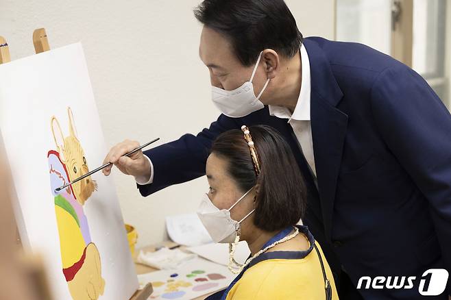 윤석열 대통령이 18일 오후 서울 강남구 충현복지관을 방문, 발달장애인 교육생들의 회화 수업을 참관하며 그림을 그려보고 있다. (대통령실 제공) 2022.8.18/뉴스1 ⓒ News1 오대일 기자