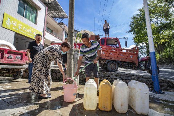 가뭄에 시달리고 있는 중국 충칭시 우산현 뤄핑 마을의 주민들이 지난 13일 급수차에서 물을 받고 있다. 중국은 지난 6월부터 30도를 웃도는 폭염이 이어지면서 가뭄에 시달리고 있다. 사진=신화연합뉴스