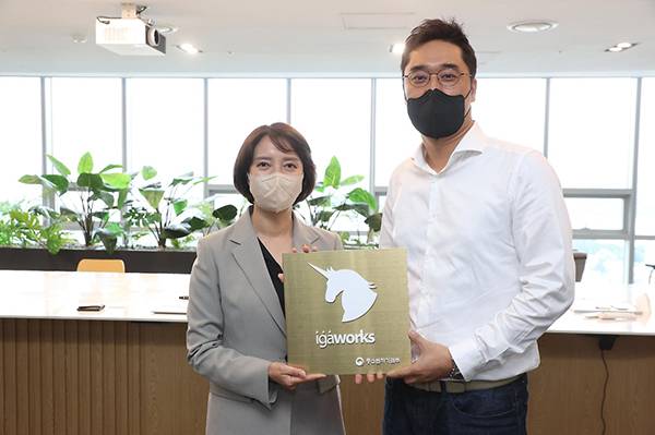이영 중소벤처기업부 장관이 지난달 21일 서울 마포구에 위치한 신규 유니콘기업 아이지에이웍스를 방문, 마국성 대표에게 유니콘기업 기념현판을 전달한 뒤 기념촬영을 하고 있다.(사진=중소벤처기업부)