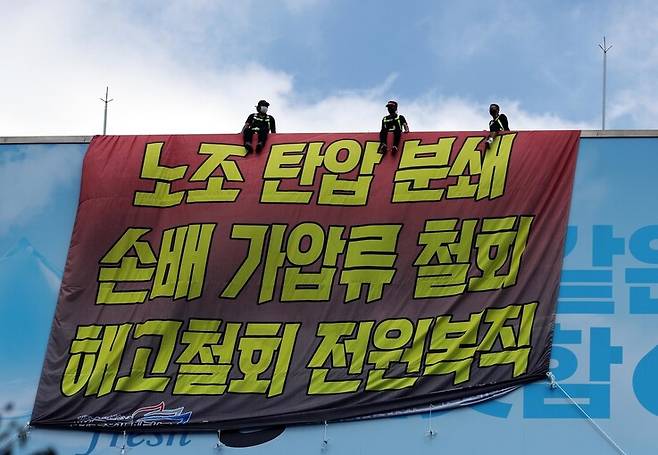 운송료 인상을 내걸고 지난 6월 2일부터 파업을 벌이고 있는 공공운수노조 화물연대본부 하이트진로지부 노조원들이 16일 오후 서울 강남구 청담동 하이트진로 본사 사옥 옥상 광고판과 1층 로비를 점거하고 농성을 벌이고 있다. 강창광 선임기자 chang@hani.co.kr