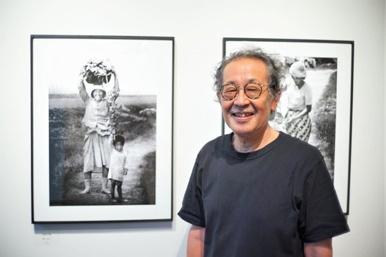한국인의 일상을 50년 넘게 찍어온 후지모토 다쿠미가 ‘김해평야’(1978년) 앞에서 포즈를 취했다. [사진 주일 한국문화원]