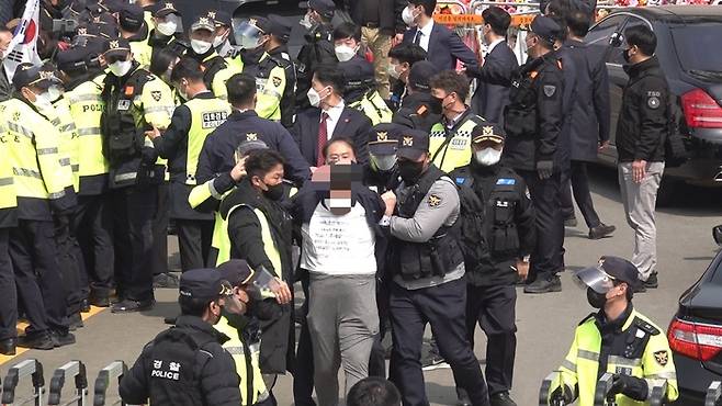 전직 대통령 박근혜씨가 지난 3월24일 대구 달성 자신의 자택 앞에서 입장을 밝히던 중 박씨를 향해 소주병을 던진 A씨(47)가 경찰에 연행되고 있다. 독자 제공