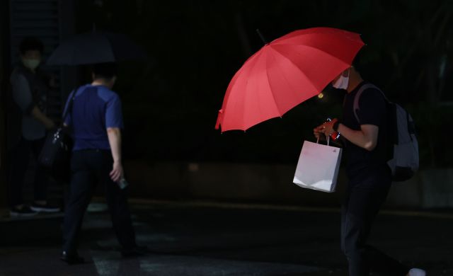 서울 서초구 고속버스터미널 앞에서 15일 우산 쓴 시민이 지나가고 있다. 연합뉴스