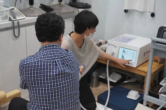 서민영 사라양한방동물병원장(사진 오른쪽)이 동물용 체외 충격파 시연을 진행 중이다/사진제공=에이치앤티메디칼