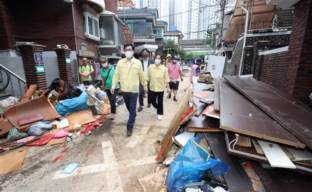 박일하(맨 앞) 동작구청장이 지난 10일 폭우로 피해를 당한 지역의 복구 작업을 확인하고 있다.동작구 제공