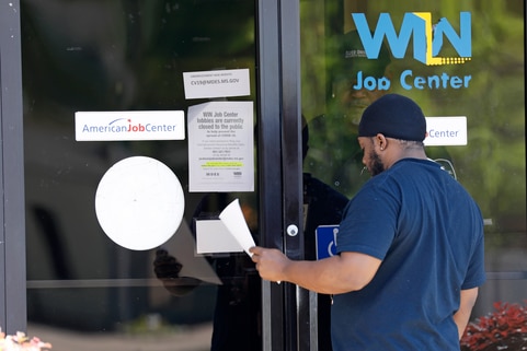 미국 미시시피 주 노스 잭슨에서 한 남성이 'WIN 잡 센터'의 유리문 뒤 경비원으로부터 실업수당 신청서를 건네받고 있다. /AP=연합뉴스
