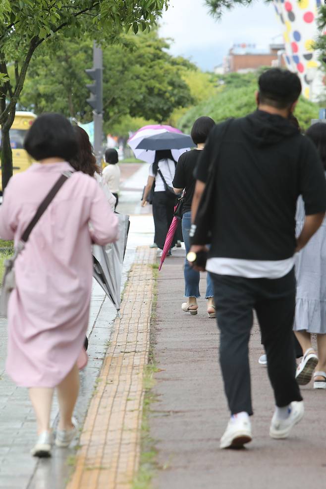 16일 오전 광주 서구 치평동에서 시민들이 가늘어진 빗줄기에 우산을 접고 출근하고 있다. [연합]
