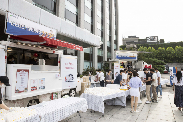 19일 오전 서울 종로구 계동 현대건설 사옥을 찾은 'CEO의 찾아가는 커피트럭' 관계자들이 임직원들에게 커피와 샌드위치를 제공하고 있다./이수민기자