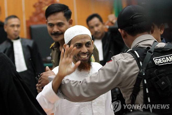 2002년 발리 폭탄 테러 주범 우마르 파텍 2012년 2월 13일 발리 폭탄 테러 주범 우마르 파텍이 첫 공판 후 웃으며 손을 흔들고 있다. 
[EPA 연합뉴스 자료사진. 재판매 및 DB 금지]