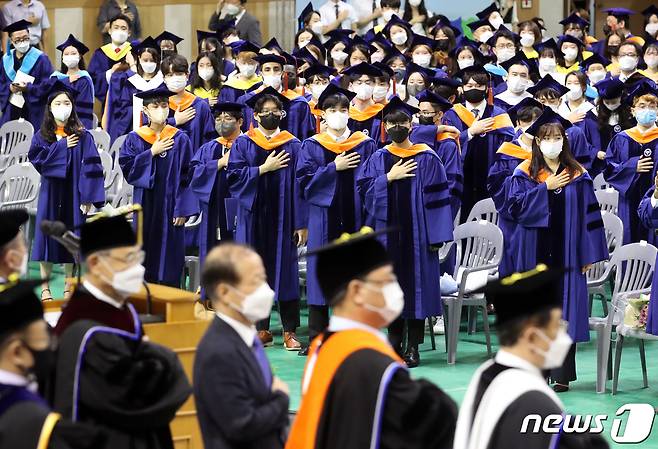 18일 서울 성동구 한양대학교 올림픽체육관에서 열린 '2021학년도 후기 학위수여식'에서 졸업생들이 국기에 경례를 하고 있다. 2022.8.18/뉴스1 ⓒ News1 송원영 기자