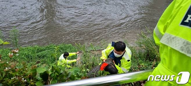 부산 동래구 온천천 인근에서 산책하던 60대 여성이 갑자기 불어난 강물에 고립돼 구조되고 있는 모습.(부산경찰청 제공)