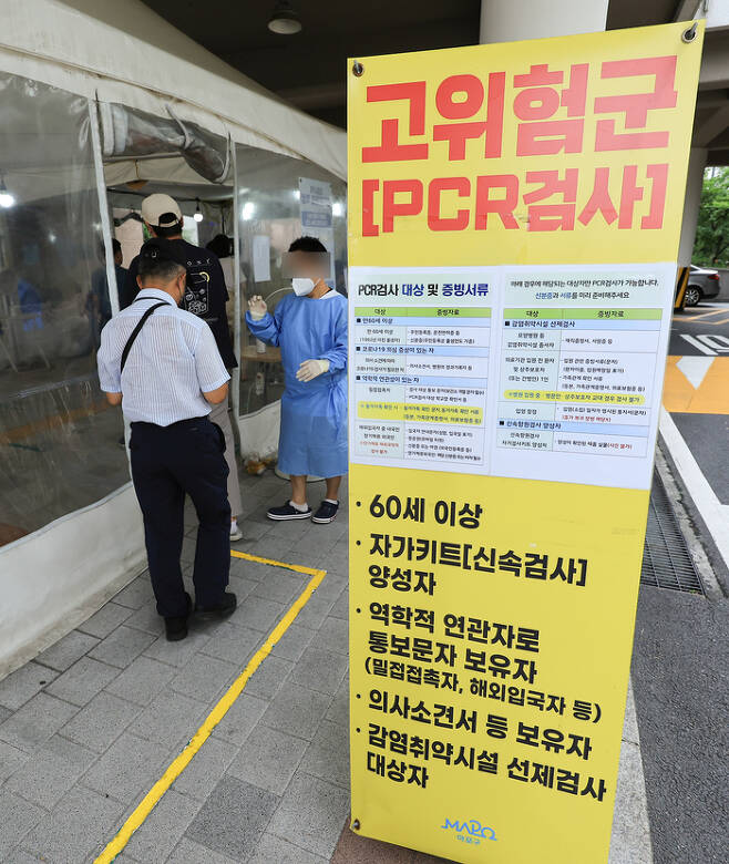 지난 19일 서울 마포구 보건소 코로나19 선별진료소를 찾은 시민들이 검사를 받기 위해 차례를 기다리고 있다.  연합뉴스