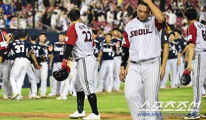 경기후, 정철원과 김현수가 사과를 주고 받고 있다.