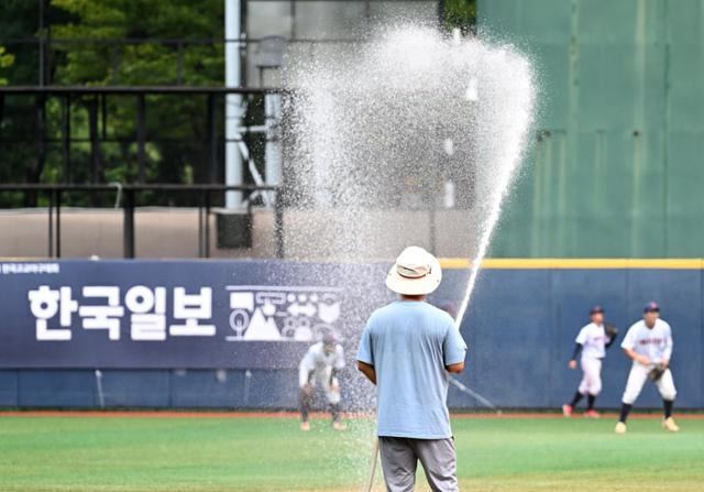 22일 서울 양천구 목동야구장에서 열린 제50회 봉황대기전국고교야구대회 2회전 광남고와 배재고 경기에 앞서 운동자 관리원이 더위를 식히기 위해 경기장에 물을 뿌리고 있다. 왕태석 선임기자